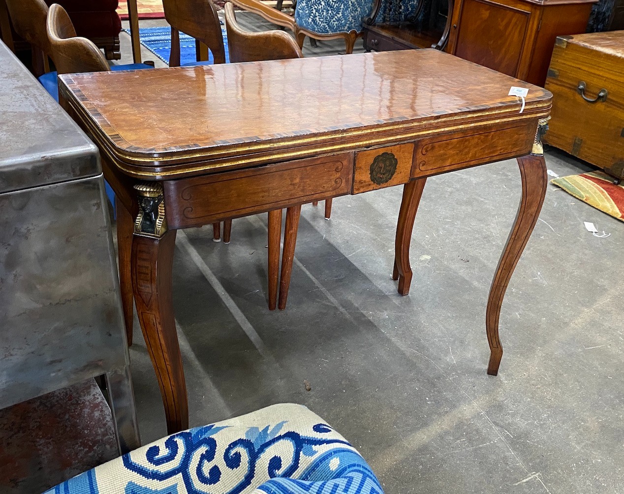 A Regency coromandel banded mahogany folding card table with parcel gilt Egyptianesque metal mounts, width 90cm, depth 44cm, height 75cm